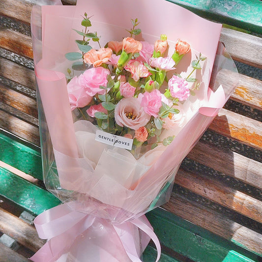 Assorted Pink and Orange Flowers with Foliage in Pink Paper Bouquet