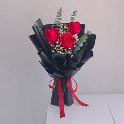 Three Red Roses with Gypsophila and Eucalyptus in Black Paper Bouquet