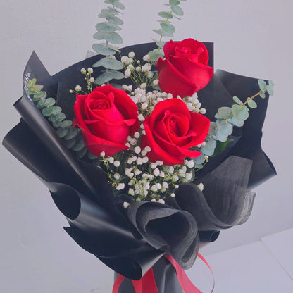 Three Red Roses with Gypsophila and Eucalyptus in Black Paper Bouquet