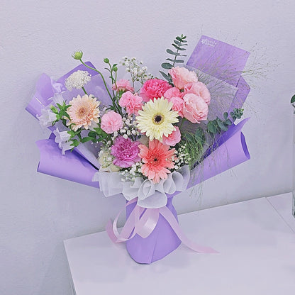 Assorted Soft Tone Flowers in Purple Paper Medium Bouquet