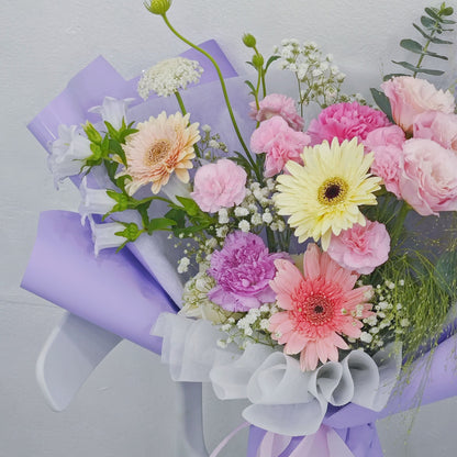Assorted Soft Tone Flowers in Purple Paper Medium Bouquet
