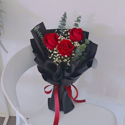 Three Red Roses with Gypsophila and Eucalyptus in Black Paper Bouquet