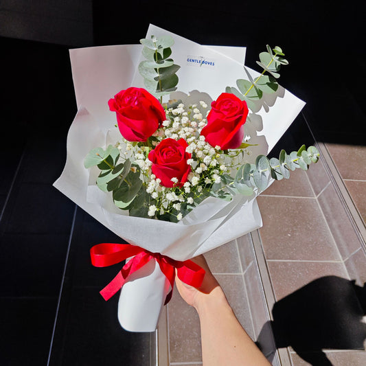 Three Red Roses with Gypsophila and Eucalyptus in White Paper Minimal Bouquet