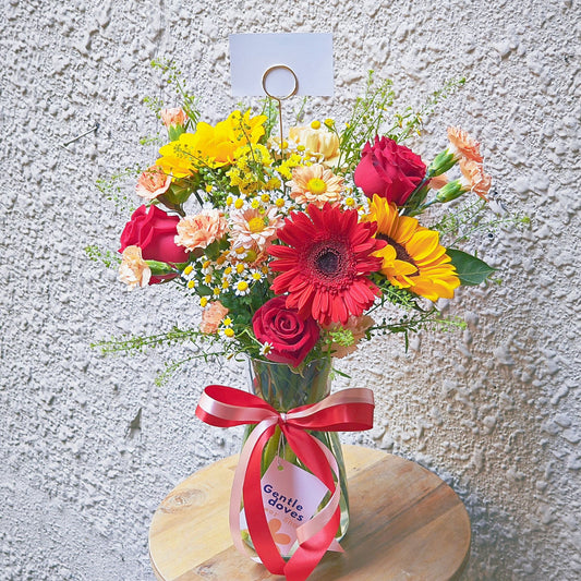 Assorted Red and Orange Flowers in Large Vase Arrangement