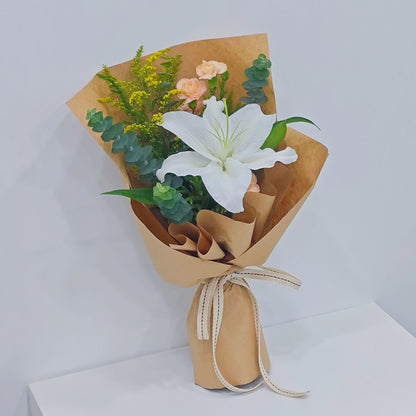 Single White Lily with Sprayed Carnations and Green Foliage in Kraft Paper Small Bouquet
