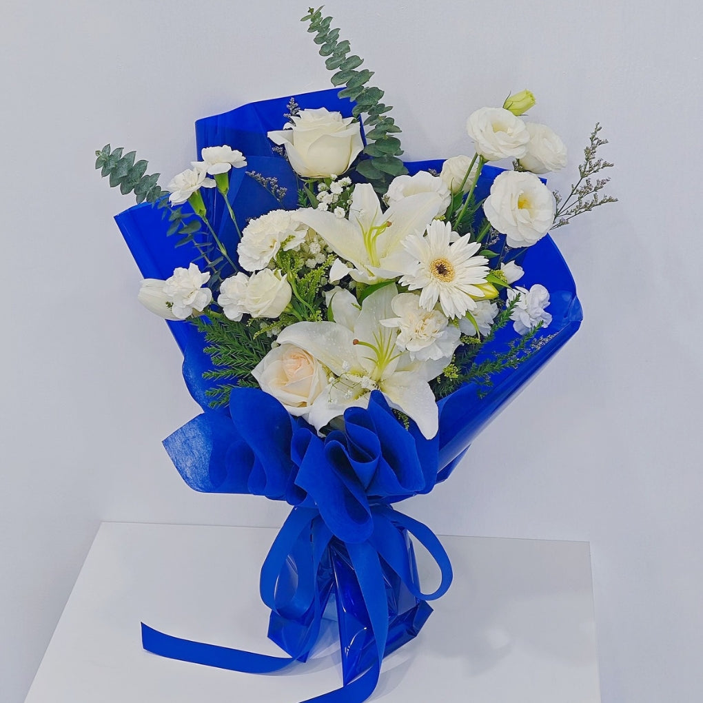 Assorted White Flowers with Lilies and Green Foliage in Blue Paper Bouquet
